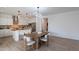 Open dining area with modern light fixture and wood table with seating, leading to the kitchen at 21266 E Via De Olivos --, Queen Creek, AZ 85142