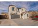 This two-story home has a gray, two car garage and desert landscaping at 21266 E Via De Olivos --, Queen Creek, AZ 85142