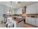 Modern kitchen featuring white cabinets, wooden accents, stainless steel appliances, and stylish pendant lighting at 21266 E Via De Olivos --, Queen Creek, AZ 85142