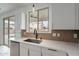 Bright kitchen showcasing a stainless steel sink, modern countertops, and white cabinetry with gold hardware at 21266 E Via De Olivos --, Queen Creek, AZ 85142