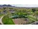 Aerial view of a basketball court, bocce ball court and playground, surrounded by lush greenery at 26764 W Ponderosa Ln, Buckeye, AZ 85396