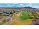 Golf course and tennis courts surrounded by beautiful landscaping, with mountain views in the background at 26764 W Ponderosa Ln, Buckeye, AZ 85396