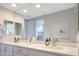 Bright bathroom with double sinks, white countertops, modern fixtures, and large mirror, creating a spa-like atmosphere at 26764 W Ponderosa Ln, Buckeye, AZ 85396