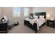 Cozy bedroom featuring dark wood furniture, white bedding, and natural light from shuttered windows at 26764 W Ponderosa Ln, Buckeye, AZ 85396