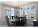 Modern dining room featuring a stylish chandelier and plantation shutters, with a sliding glass door to the patio at 26764 W Ponderosa Ln, Buckeye, AZ 85396