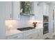 Modern kitchen with white cabinets, stainless steel appliances, and a gray herringbone backsplash at 26764 W Ponderosa Ln, Buckeye, AZ 85396