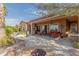 Inviting covered patio with cozy seating, a built-in grill, and an outdoor fireplace overlooking the desert landscape at 29390 N 128Th Ln, Peoria, AZ 85383