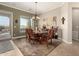 Elegant dining room with a wood table, chandelier lighting, and views of the outdoor scenery at 29390 N 128Th Ln, Peoria, AZ 85383