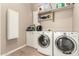 Well-lit laundry room featuring a front-load washer and dryer set with extra storage and folding space at 29390 N 128Th Ln, Peoria, AZ 85383