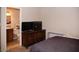 A bedroom with a TV on a wooden dresser, next to the bathroom at 3227 W Villa Rita Dr, Phoenix, AZ 85053