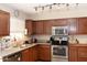 Well-lit kitchen featuring stainless steel appliances, light countertops, and dark wood cabinetry at 3227 W Villa Rita Dr, Phoenix, AZ 85053