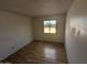 This empty bedroom features wood-look floors and a window overlooking the outdoor area at 3452 E Evans Dr, Phoenix, AZ 85032