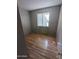 This empty bedroom features wood-look floors and natural light from window with blinds at 3452 E Evans Dr, Phoenix, AZ 85032