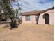 Exterior of a stucco home with xeriscaping and large trees, providing a natural, drought-friendly landscape at 3452 E Evans Dr, Phoenix, AZ 85032