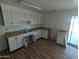 Kitchen and dining area with white cabinets, wood-look floors, and yard access at 3452 E Evans Dr, Phoenix, AZ 85032