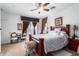 Bright bedroom featuring a ceiling fan, decorative curtains, and a comfortable bed with floral bedding at 3588 S 257Th Ave, Buckeye, AZ 85326