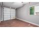 Clean, empty garage with a white garage door, grey walls, and a window at 3588 S 257Th Ave, Buckeye, AZ 85326