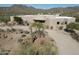 Expansive aerial view of home displaying architectural design, desert landscaping, and circular driveway, set in a rural area at 36102 N Creek View Ln, Cave Creek, AZ 85331