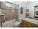 Cozy bathroom with earth tone tiling in the shower/tub and a light colored vanity at 36102 N Creek View Ln, Cave Creek, AZ 85331