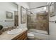 Well-lit bathroom featuring neutral stone tile, glass enclosed tub/shower, and attractive design elements at 36102 N Creek View Ln, Cave Creek, AZ 85331