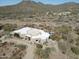 Aerial view of Southwestern home with a flat roof, neutral tones, desert landscape, and mountain backdrop at 36102 N Creek View Ln, Cave Creek, AZ 85331