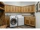 Functional laundry room featuring wood cabinets, a sink, and modern washer and dryer units for convenient chores at 36102 N Creek View Ln, Cave Creek, AZ 85331