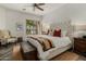 Cozy bedroom with a tufted headboard, blanket chest and a sunlit window with a view at 36102 N Creek View Ln, Cave Creek, AZ 85331