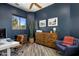 Cozy home office with a blue accent wall, light wood floors, and bright natural light at 36102 N Creek View Ln, Cave Creek, AZ 85331