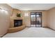 Bright living room with a unique corner fireplace and sliding door to a balcony at 36601 N Mule Train Rd # C38, Carefree, AZ 85377