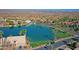 Aerial view of the community with homes surrounding a peaceful lake, lush landscapes, and distant mountains at 3830 E Lakewood E Pkwy # 2009, Phoenix, AZ 85048