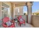 This balcony features two red Adirondack chairs, a table with flowers, and views of the neighborhood at 3830 E Lakewood E Pkwy # 2009, Phoenix, AZ 85048