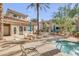 Outdoor hot tub surrounded by lounge chairs, tables and umbrellas, with buildings and trees in the background at 3830 E Lakewood E Pkwy # 2009, Phoenix, AZ 85048