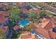 Aerial view of a pool and common area with palm trees and red tile roofs in a residential neighborhood at 3830 E Lakewood E Pkwy # 2009, Phoenix, AZ 85048