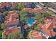 Aerial view of the community pool surrounded by palm trees and condos with red tile roofs at 3830 E Lakewood E Pkwy # 2009, Phoenix, AZ 85048