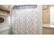 Bathroom with a toilet, shower with patterned curtain, grab bars, and shelving at 384 Gypsum Dr, Apache Junction, AZ 85119