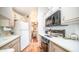 Bright kitchen with white cabinets, a white refrigerator, a black microwave, and a view into the bedroom at 384 Gypsum Dr, Apache Junction, AZ 85119