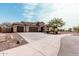 Spacious home featuring a three-car garage, stone details, desert landscaping, and a long driveway at 4187 N 183Rd Dr, Goodyear, AZ 85395