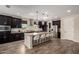 Modern kitchen with dark cabinets, stainless steel appliances, and spacious center island at 4187 N 183Rd Dr, Goodyear, AZ 85395