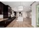 Open kitchen with dark cabinets, an island with seating, stainless steel appliances, and an elegant pendant light at 4187 N 183Rd Dr, Goodyear, AZ 85395