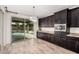 Stylish kitchen area with dark cabinetry, stainless steel appliances, granite countertops, and a view of the pool at 4187 N 183Rd Dr, Goodyear, AZ 85395