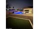 Night view of a backyard pool with a covered patio and outdoor seating, perfect for entertaining at 4187 N 183Rd Dr, Goodyear, AZ 85395