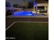 Stunning backyard pool with vibrant lighting and lush landscaping is perfect for relaxing or entertaining guests at 4187 N 183Rd Dr, Goodyear, AZ 85395