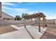 Large backyard with a wooden pergola, a concrete patio, and a gravel landscape at 44321 Cypress Ln, Maricopa, AZ 85138