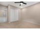 Neutral bedroom featuring a ceiling fan, closet with sliding doors, and carpet flooring at 44321 Cypress Ln, Maricopa, AZ 85138