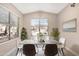 Stylish dining area with modern furniture, neutral tones, and large windows for abundant natural light at 44321 Cypress Ln, Maricopa, AZ 85138