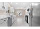 Well-lit kitchen featuring white cabinets, stainless steel appliances, and a view to the backyard through a large window at 44321 Cypress Ln, Maricopa, AZ 85138