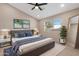 Bright main bedroom featuring a ceiling fan, window with blinds, and two pieces of framed wall art at 44321 Cypress Ln, Maricopa, AZ 85138