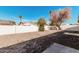 The backyard has a gravel ground cover, concrete pads, and a white fence and wall at 4720 N 63Rd Ave, Phoenix, AZ 85033