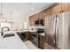 Modern kitchen features stainless steel appliances and a large center island, with a built-in wine refrigerator at 4720 N 63Rd Ave, Phoenix, AZ 85033