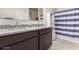 Bathroom with double sinks, granite counters, and a blue and white striped shower curtain at 5180 E Diatomite Dr, San Tan Valley, AZ 85143